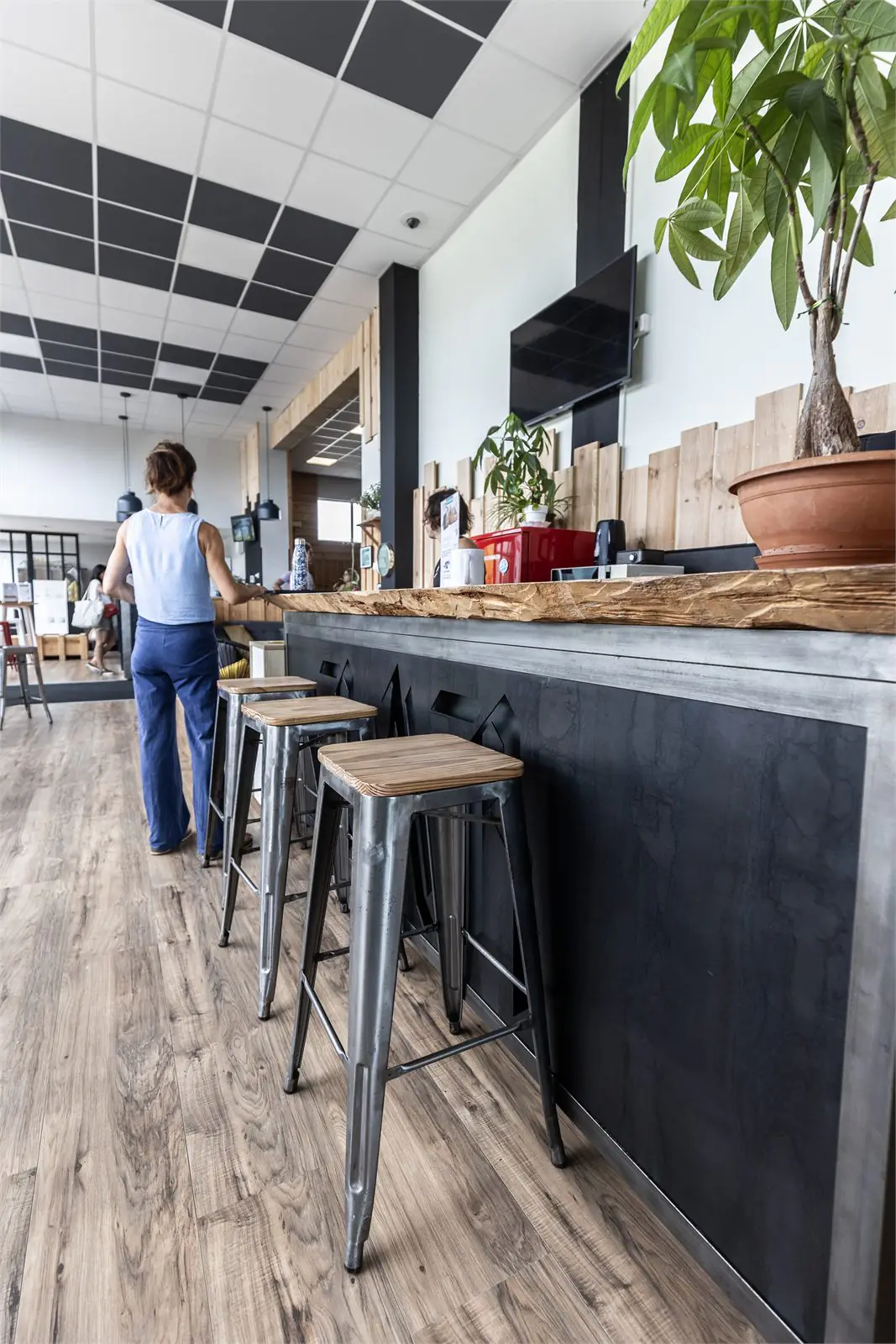 Espace bar et détente du Garden Fitness : comptoir en bois et tabourets