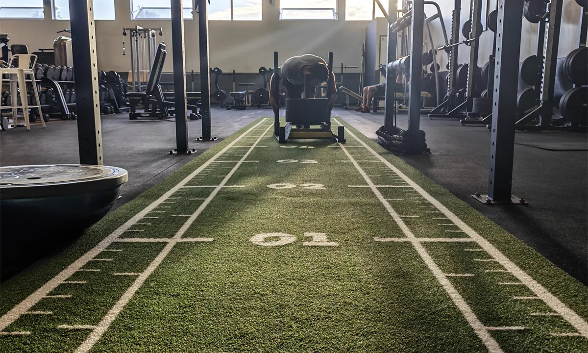 Espace Cross Training / Hyrox du Garden Fitness : zone en gazon synthétique, cage et sled